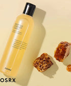 COSRX propolis synergy toner bottle with honeycomb pieces on a beige background