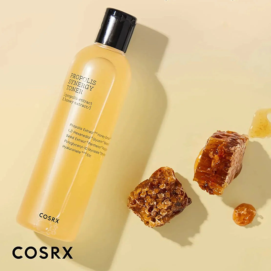 COSRX propolis synergy toner bottle with honeycomb pieces on a beige background