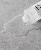 Tube of skincare product on a textured gray surface