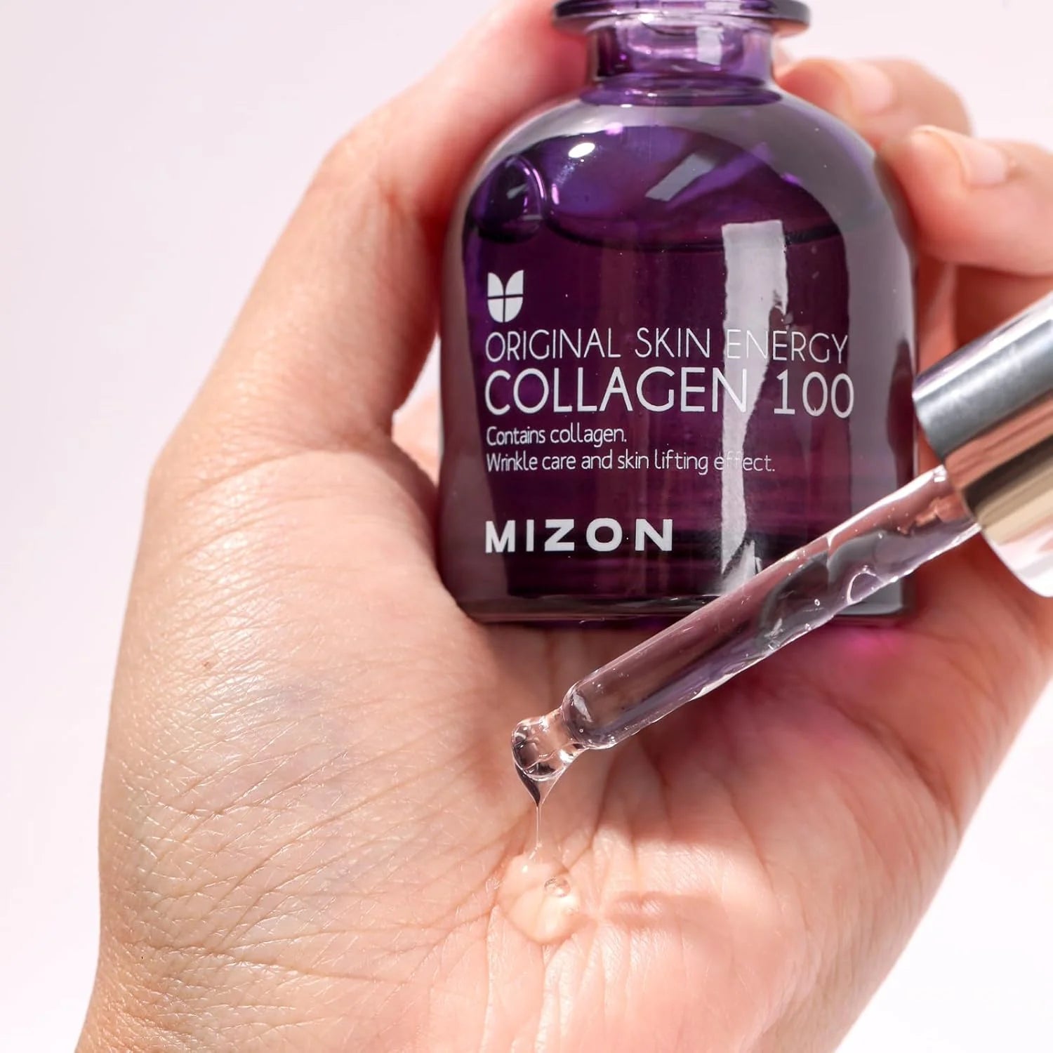 Mizon Collagen 100 skincare product being held in a hand with a dropper.