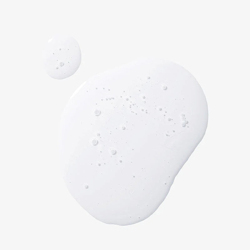 Close-up of a white cream or lotion with bubbles on a light gray background