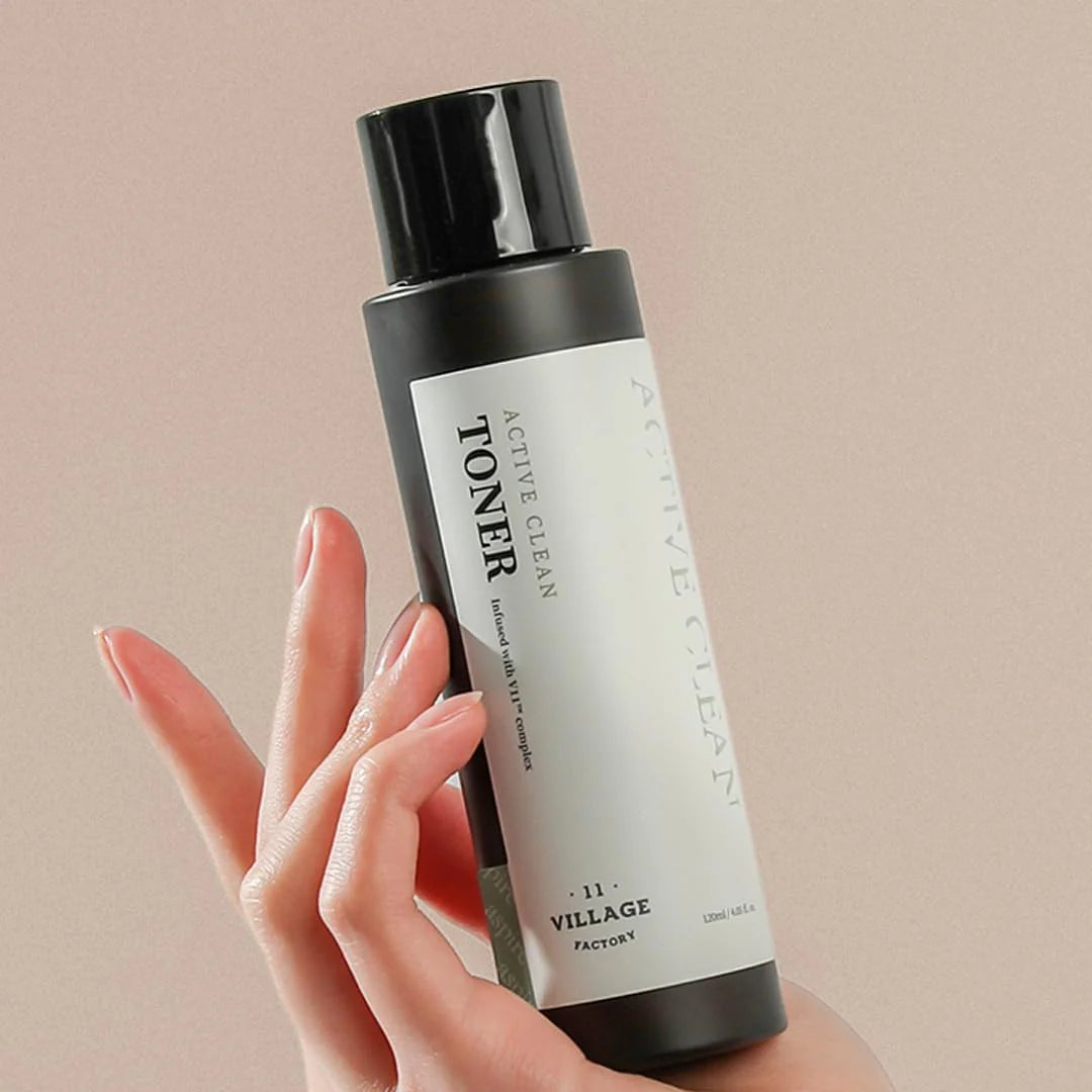 Hand holding a bottle of toner with a beige background