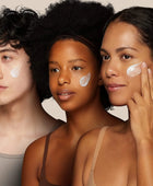 Three people with cream applied to their faces against a neutral background