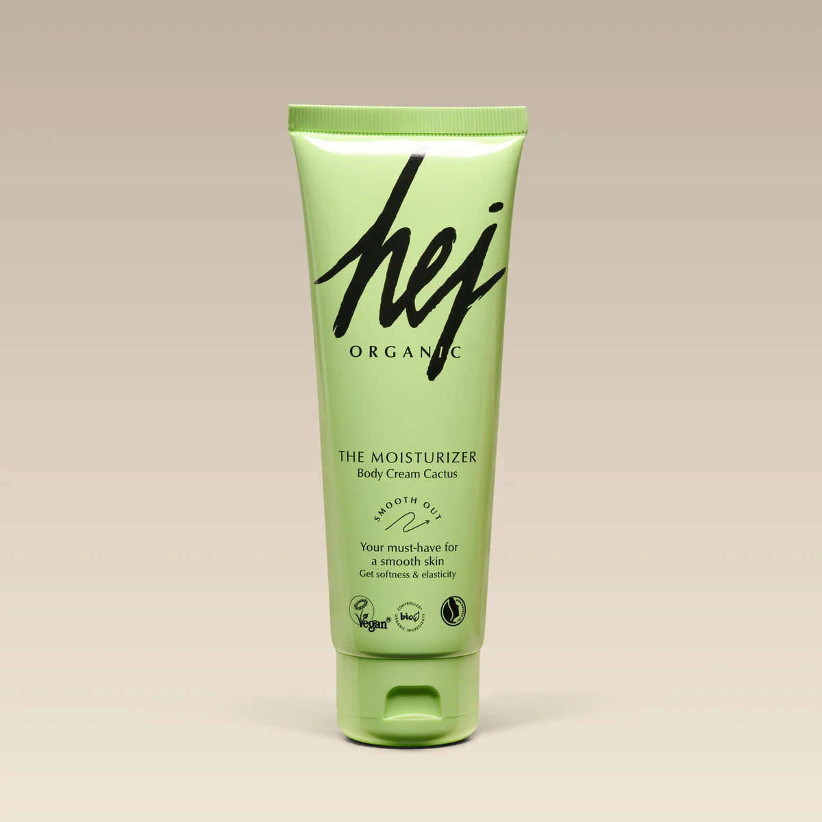 Green tube of hej organic moisturizer on a beige background