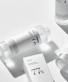 Skincare products with '77%' branding on a light gray background